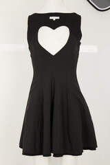 Chic black sleeveless skater dress featuring a prominent heart shaped cutout at the neckline and a flared skirt for a playful yet stylish look © mdishakrahman