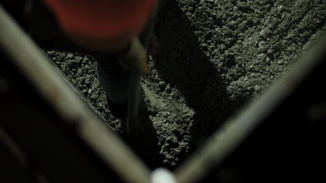Vibrating fresh concrete during compaction inside formwork