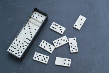 Domino tiles on dark surface, classic board game pieces, strategy and logic concept
