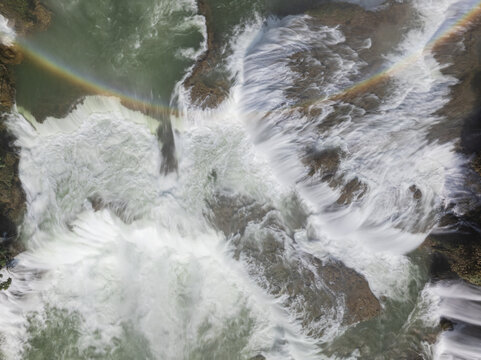 Aerial view of the Quy Xuan River's cascading waters, a vibrant rainbow arching over the falls in a breathtaking dance of light and mist, Cao Bang, Cao Bang, Vietnam.