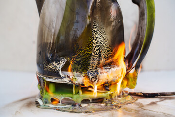A electric kettle engulfed in flames, with the fire brightly illuminating its surface and rising...