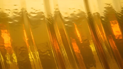 Abstract shimmering golden surface with undulating textures and diagonal highlights creating a