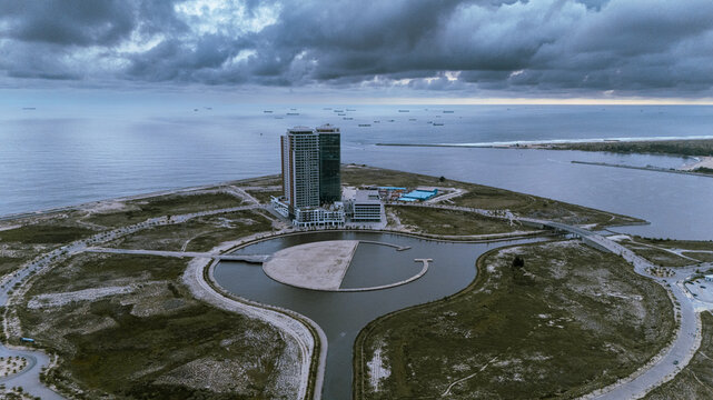 Aerial view of modern architecture meeting the vast ocean under a brooding sky at Eko Atlantic, Lagos, Lagos, Nigeria.