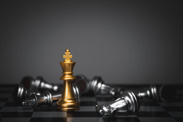 A golden king chess piece standing among defeated silver pieces symbolizes leadership, strategy,...