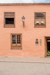 Garachico, Tenerife, Spain - Charming coral-colored building with wooden window frames and traditional architecture, showcasing the beauty of local design