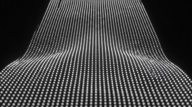 Abstract digital wave pattern created by a grid of white lights on a dark background, creating a visual representation of sound waves or data streams