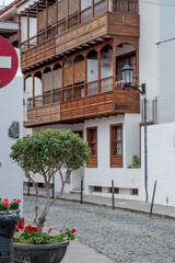 Garachico, Tenerife, Spain, Traditional wooden balcony overlooking a quaint street, adorned with greenery and vibrant flowers