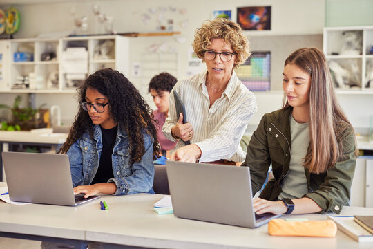 Teacher assisting student during computer class