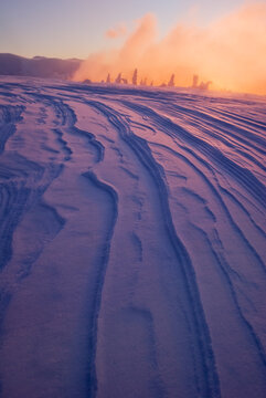 View of snowdrift patterns sculpted by the wind under a warm, ethereal glow, creating a serene winter landscape, Low Tatras, Banska Bystrica Region, Slovakia.