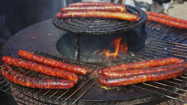 Sausages grilling on hot barbecue street food.