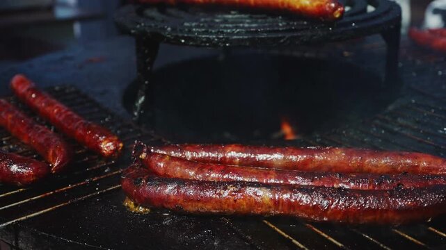 Sausages grilling on hot barbecue street food.