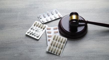 Judge gavel and medical pills on the table.