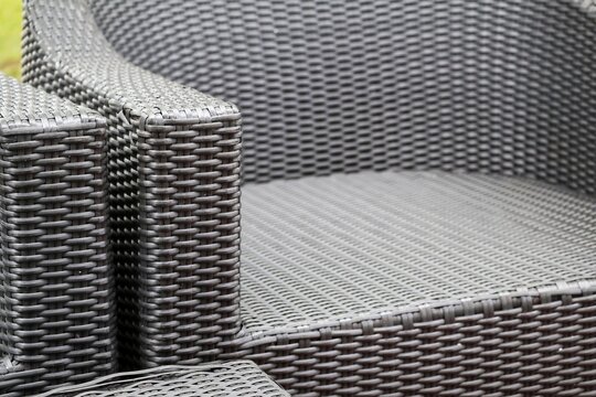 Plastic chair with woven texture, combining traditional woven aesthetics with modern durable material for indoor or outdoor use.