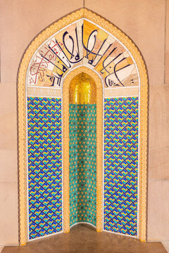 View of a golden mihrab alcove with intricate turquoise and blue tilework and Arabic calligraphy, Sultan Qaboos Street, Muscat, Muscat Governorate, Oman.
