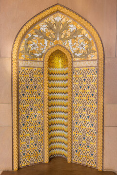 View of intricate golden patterns adorn an arched niche, a dazzling display of craftsmanship and cultural artistry, Muscat, Muscat Governorate, Oman.