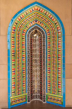 View of an intricately designed, arched niche with vibrant geometric patterns and reflective surfaces, showcasing the artistry of Oman, Muscat, Muscat Governorate, Oman.