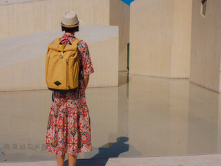 Young woman exploring Qasr Al Hosn Park in Abu Dhabi. Surrounded by lush greenery and historical landmarks, she enjoys the serene atmosphere and Emirati heritage in heart of city.