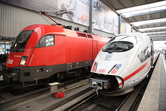 MUNICH - SEP 23, 2009: A red and white train is parked next to each other. The red locomotive is a OBB train, while the white is a DB firm