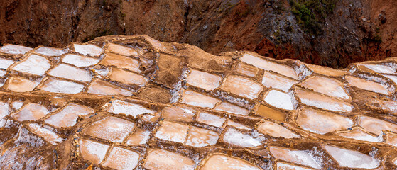 Maras, Cusco, Peru. panoramic view of the terraced salt ponds revealing geometric patterns and mineral textures shaped by centuries of traditional harvesting