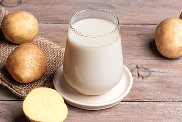 Vegan potato milk on wooden background