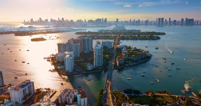 Setting sun dazzles the waterscape of Biscayne Bay. Drone footage distancing from Brickel Key, Miami, Florida.