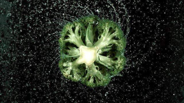 Fresh broccoli spinning in slow motion on black background with water drops - Powered by Adobe