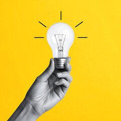 Hand holds a clear lightbulb, illuminated against a solid bright yellow background