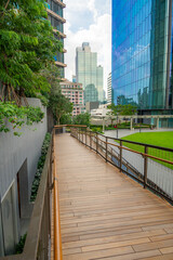 Walkways and wooden paths in Dusit Park on a Bangkok rooftop, surrounded by fresh greenery and offering elevated city views that blend modern design with calm natural space.