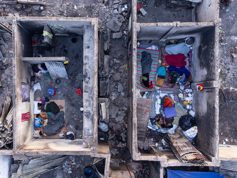 Dhaka, Bangladesh - 28 November 2025: Aerial view of cramped living spaces reveal a stark contrast between the rough concrete structures and the colorful personal belongings within.
