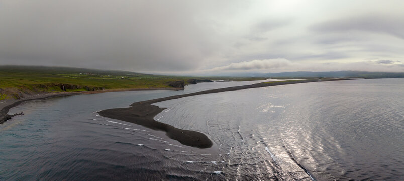drone view of Sandvik and its long black lava sand beach in East Iceland