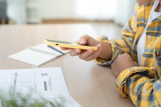 Modern woman use phone to scan barcode or QR codes to pay credit card bill after receive document invoice. payment, receive, paying electricity, digital payments without money, technology, scanning - Powered by Adobe