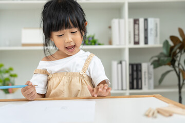 Naklejka premium Happy Asia children learning and enjoy paint. family is happy and excited in the house. Mother and daughter having fun spending time together. Holiday, Activity, Executive Function, IQ, EQ
