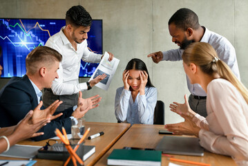 In a tense corporate meeting, an Asian female employee shows distress while aggressive coworkers shout at her. She covers her ears, overwhelmed by the mobbing behavior from her colleagues.