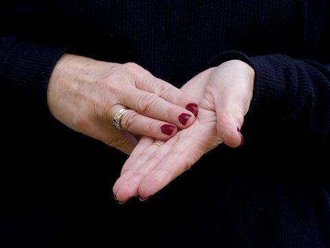 A pair of hands signing the consonant letter 'M' in British Sign Language.BSL.Communication.Hearing Impaired.