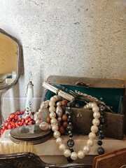Vintage-style scene with various old-fashioned personal items and jewelry arranged on a surface
