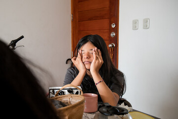 A teen is sitting at a table with a cup in front of her