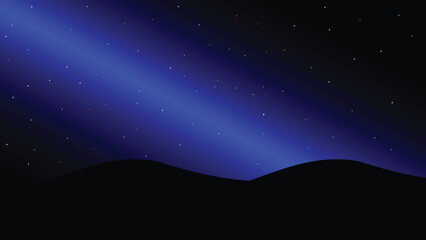 The night sky is blue and the stars are beautiful under the dark shadows of the mountains.
