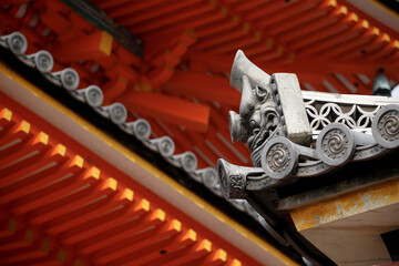 Light and shadow emphasize the dramatic features of the Onigawara perched atop the Japanese traditional roof