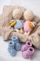 Handmade crochet baby toys set featuring three cute sleeping angel dolls and knitted baby booties in soft pastel colors.