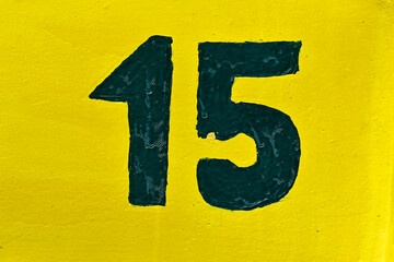Number fifteen on yellow surface