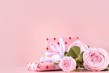 Valentine day, February 14 holiday background with pink roses flowers bouquet, gift boxes and heart-shaped chocolates on pastel colored pink background copy space