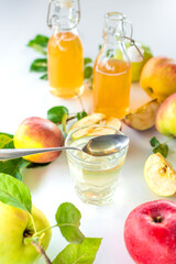 Apple cider vinegar against a background of apples. Selective focus.