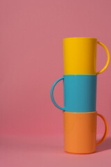 Stacked Colorful Coffee Mugs on Pink Background