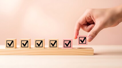 Hand placing a pink wooden block with a checkmark onto a wooden base completing a task list