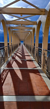 Seaside Pier Tunnel Leading Into Horizon on a Sunny Day