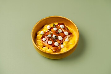 A delightful bowl filled with creamy mac and cheese features tender grilled chicken pieces adorned with fresh herbs. This dish tempts the senses with its rich flavors and textures