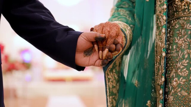 Bride and groom Mehndi reaching out each others hands during Wedding Photoshoot. 