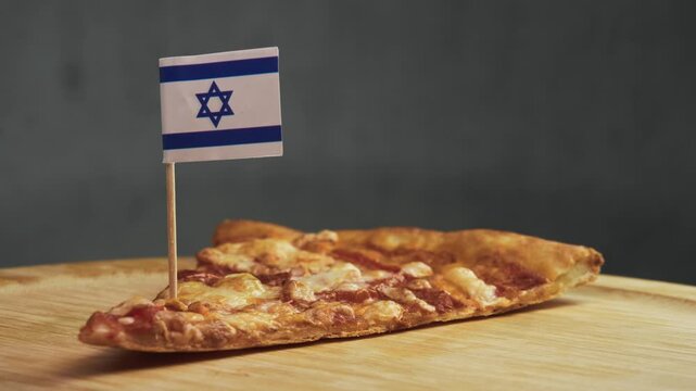 Close up shot of single pizza slice with Israeli flag on toothpick, scene highlights kosher cheese, locally milled wheat flour and Israeli approach to tomato cheese pizza.
