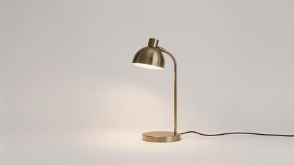 A modern desk lamp with a metallic finish and a black power cord, set against a plain light background.