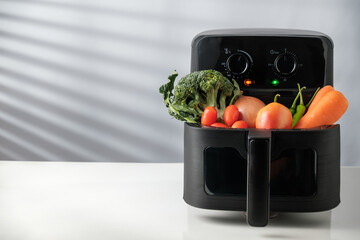 Fresh Vegetables in Air Fryer Basket with copy space for text.